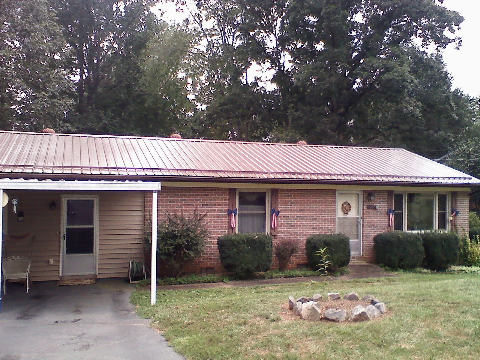 Bronze metal roof and carport on a brick ranch home — Roof Repair work by our crew in Winton