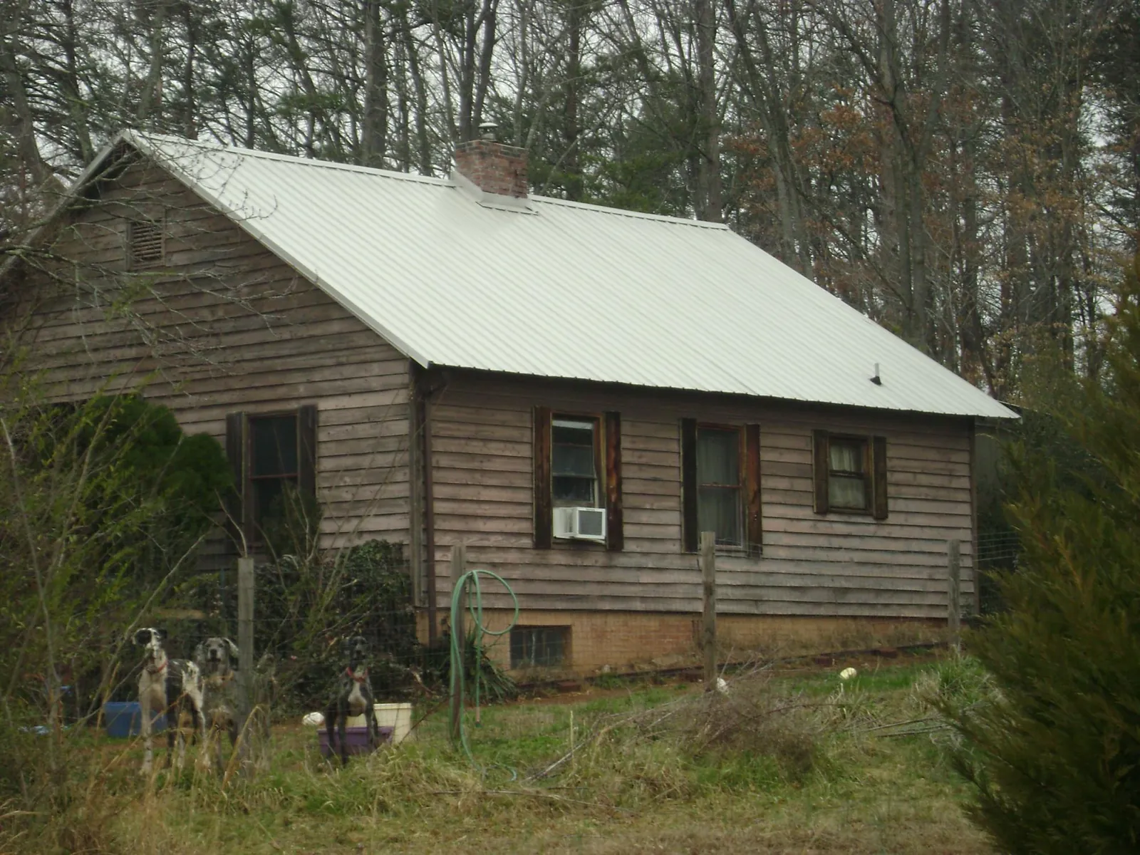 White metal roof on an old wood sided farmhouse, from a Metal Roof Installation job in Winton